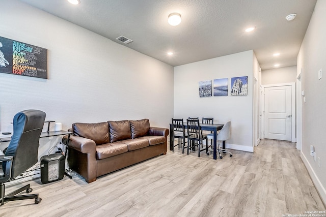 living room with visible vents, baseboards, wood finished floors, and recessed lighting