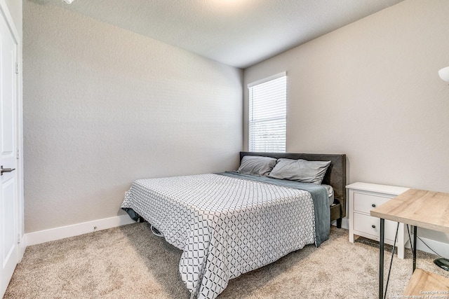 bedroom with light carpet and baseboards