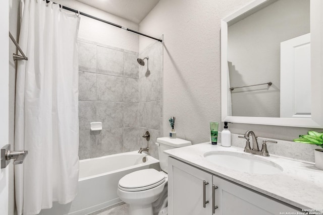 bathroom featuring a textured wall, shower / bath combo with shower curtain, vanity, and toilet
