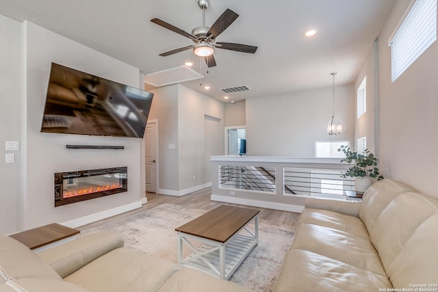 living room with ceiling fan, recessed lighting, visible vents, and light wood-style flooring
