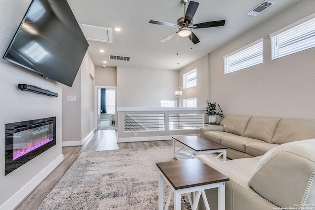 living area with recessed lighting, visible vents, light wood finished floors, and ceiling fan