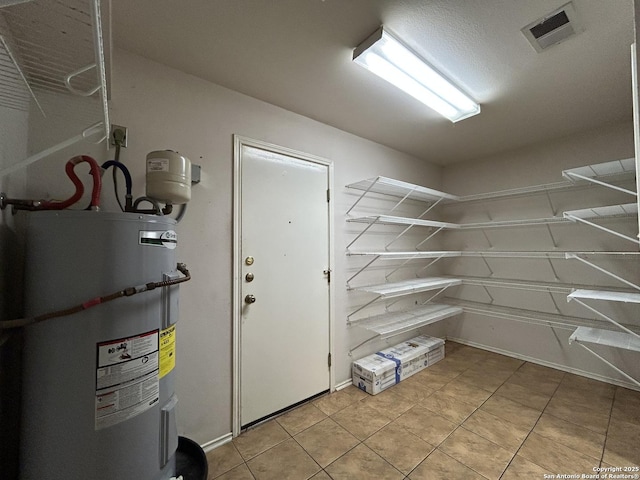 pantry with visible vents and electric water heater