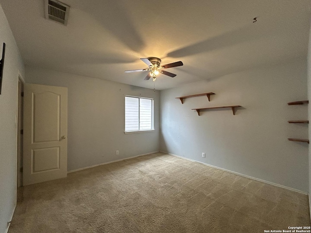 spare room featuring baseboards, ceiling fan, light colored carpet, and visible vents