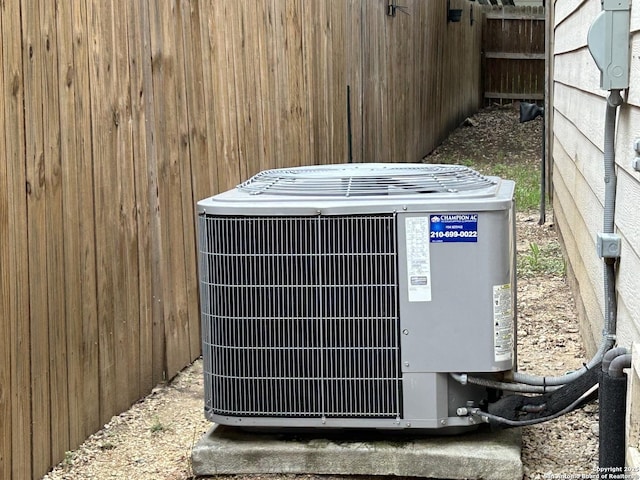 exterior details with central air condition unit and fence