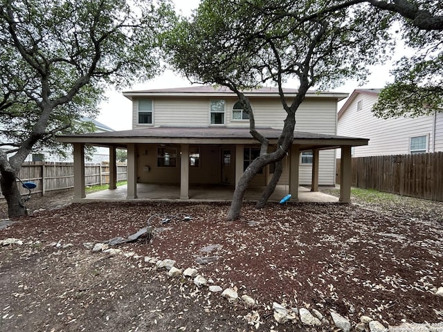 back of house with a fenced backyard and a patio area