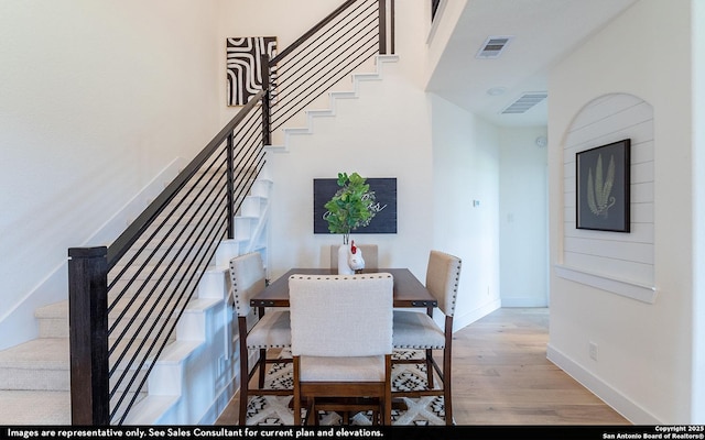 dining space with baseboards, wood finished floors, stairs, and visible vents