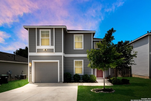 traditional home with a lawn, driveway, central AC unit, and a garage