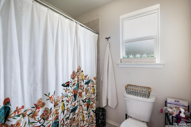 full bathroom featuring baseboards, curtained shower, and toilet