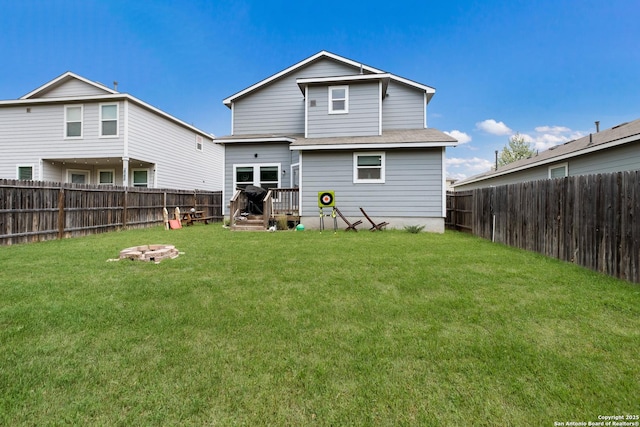 back of property with a lawn and a fenced backyard