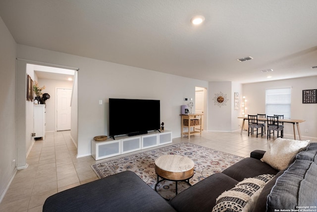 living area featuring baseboards, light tile patterned flooring, and visible vents