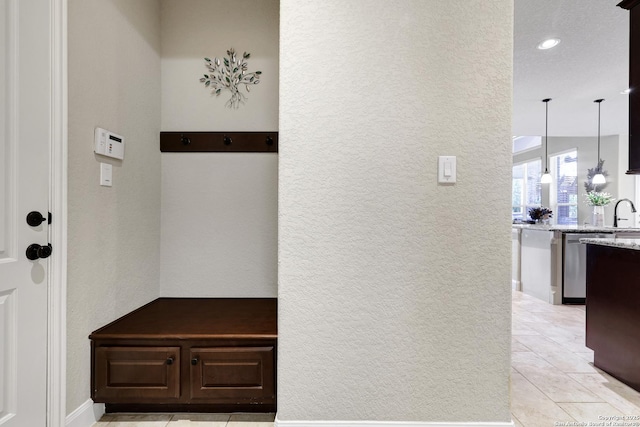 mudroom featuring a textured wall, recessed lighting, and light tile patterned flooring