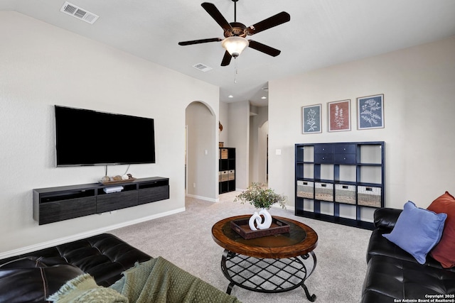 living room with a ceiling fan, carpet floors, arched walkways, and baseboards