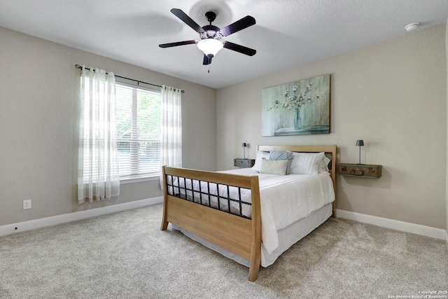 bedroom with baseboards, light colored carpet, and a ceiling fan