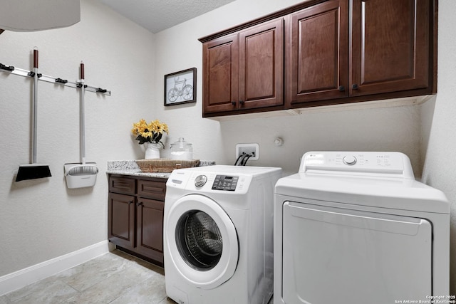 laundry room featuring independent washer and dryer, cabinet space, and baseboards