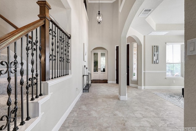 foyer with arched walkways and a chandelier