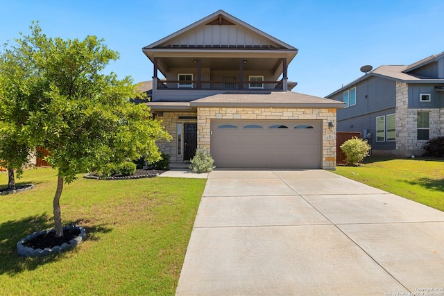 view of front facade featuring a balcony, concrete driveway, a front lawn, stone siding, and board and batten siding