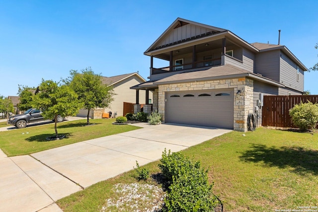 traditional-style home featuring stone siding, concrete driveway, fence, a balcony, and board and batten siding