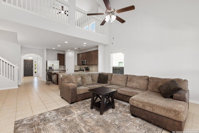 6772 Concho, Schertz, TX 78108 - living area with arched walkways, baseboards, a towering ceiling, ceiling fan, and light tile patterned floors