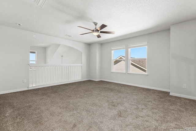 spare room featuring visible vents, carpet, a textured ceiling, and ceiling fan