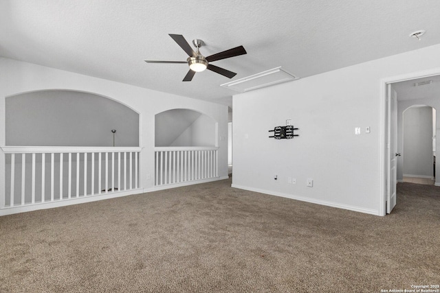 carpeted spare room featuring attic access, a textured ceiling, a ceiling fan, and visible vents