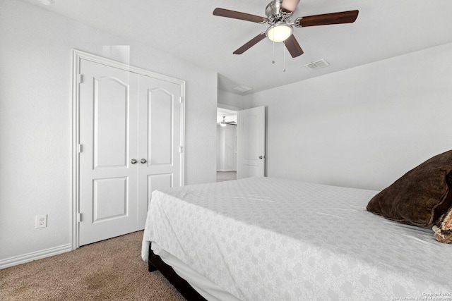 bedroom with baseboards, visible vents, a ceiling fan, a closet, and carpet floors
