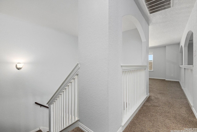 6772 Concho, Schertz, TX 78108 - hallway with arched walkways, a textured wall, visible vents, and carpet