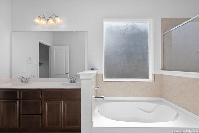 bathroom with a garden tub, a sink, and double vanity