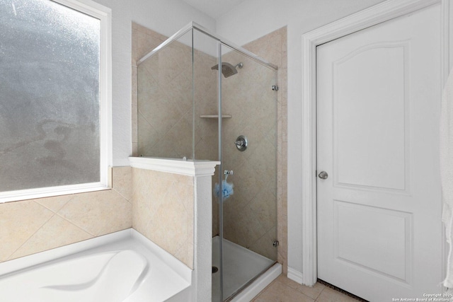 full bath featuring a shower stall, a bath, and tile patterned floors