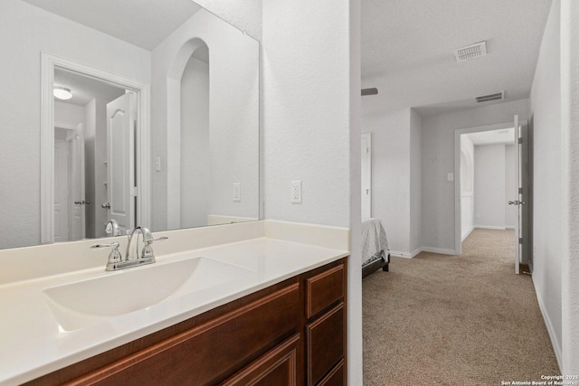 bathroom featuring baseboards, visible vents, and vanity