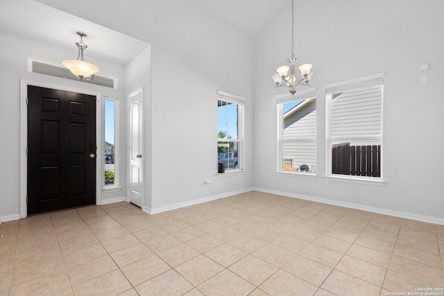 foyer entrance with a chandelier, a healthy amount of sunlight, baseboards, and light tile patterned floors