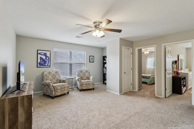 sitting room with baseboards, a ceiling fan, carpet flooring, and visible vents
