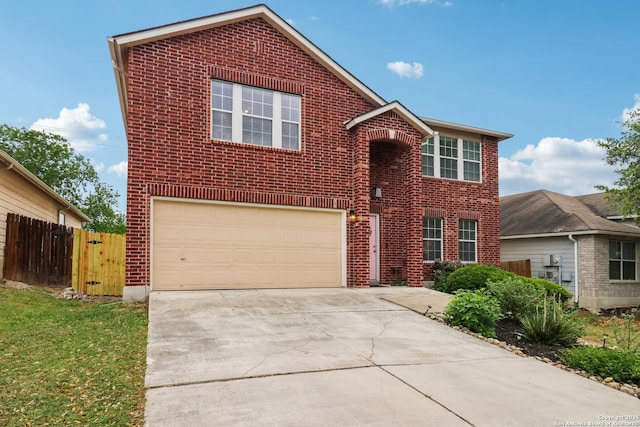 traditional home with fence, concrete driveway, brick siding, and a garage