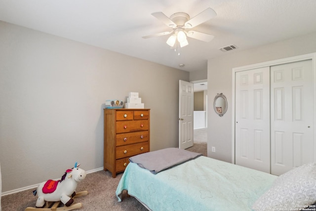 carpeted bedroom featuring a closet, visible vents, baseboards, and ceiling fan