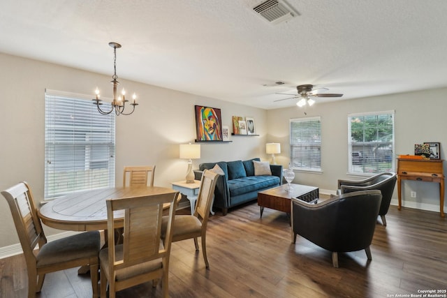 interior space with dark wood finished floors, visible vents, and ceiling fan with notable chandelier
