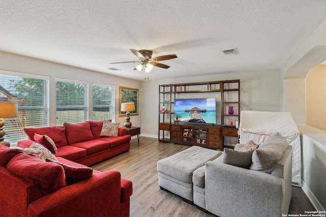 living room with ceiling fan, baseboards, wood finished floors, and visible vents