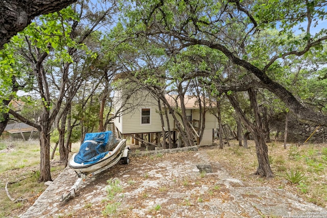 view of yard with dirt driveway and stairs