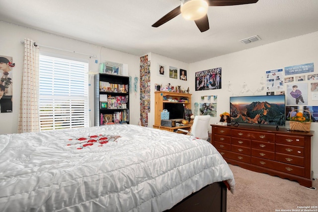 bedroom with carpet, visible vents, and ceiling fan