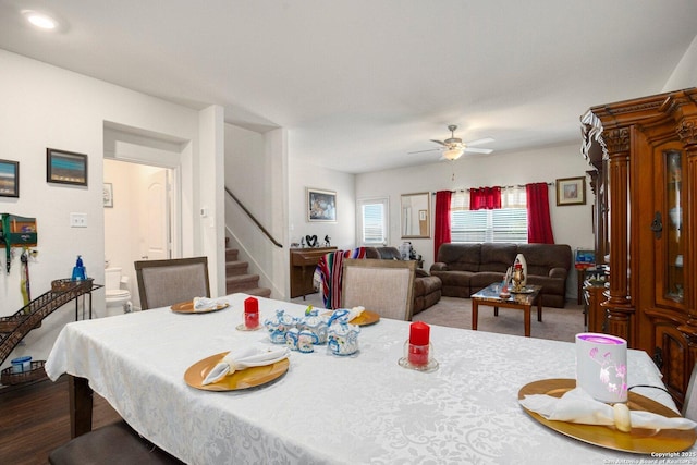 dining area featuring a ceiling fan and stairs