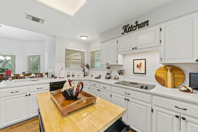 kitchen with visible vents, backsplash, white cabinetry, and a healthy amount of sunlight