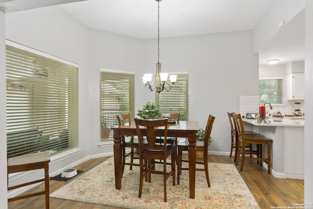 dining space featuring baseboards, an inviting chandelier, and dark wood-type flooring