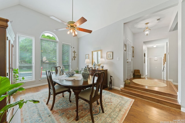 dining room with light wood-style flooring, lofted ceiling, baseboards, and a ceiling fan