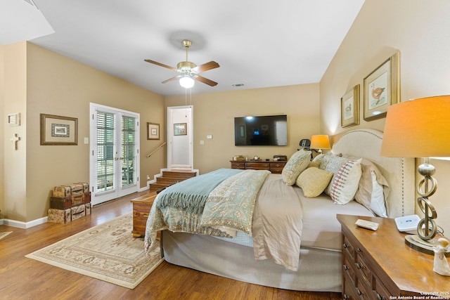 bedroom featuring wood finished floors, access to exterior, a ceiling fan, visible vents, and baseboards
