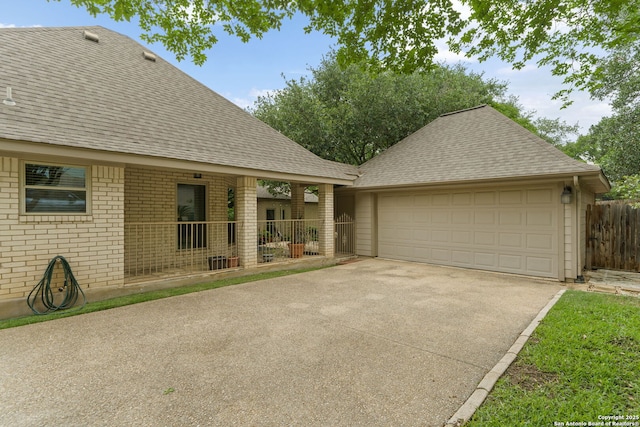 ranch-style house with brick siding, roof with shingles, fence, and a garage
