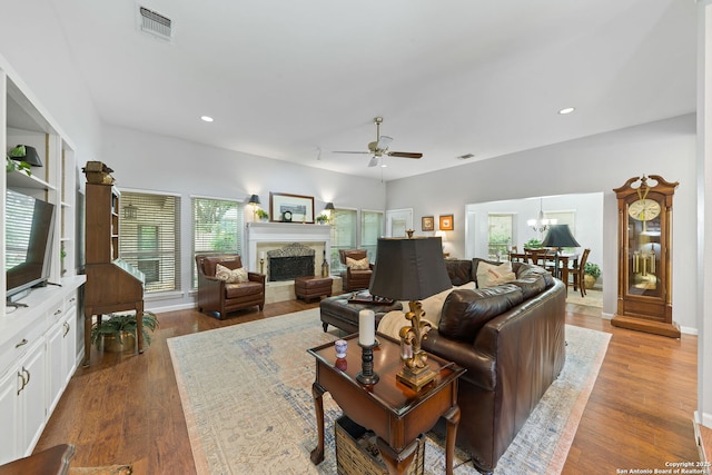 living room with a fireplace, recessed lighting, a healthy amount of sunlight, and ceiling fan with notable chandelier