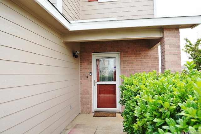 doorway to property with brick siding