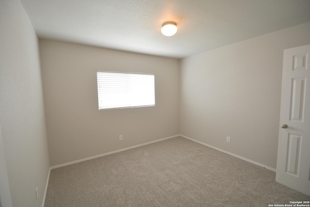 empty room with baseboards and carpet flooring