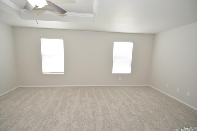 spare room with a ceiling fan, baseboards, crown molding, and carpet