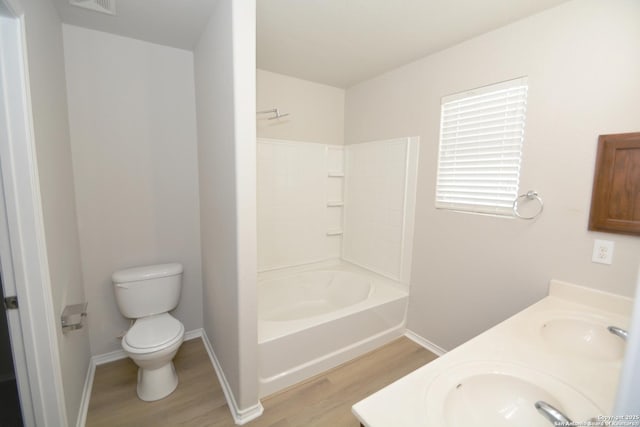 full bath featuring baseboards, toilet, wood finished floors, and a sink