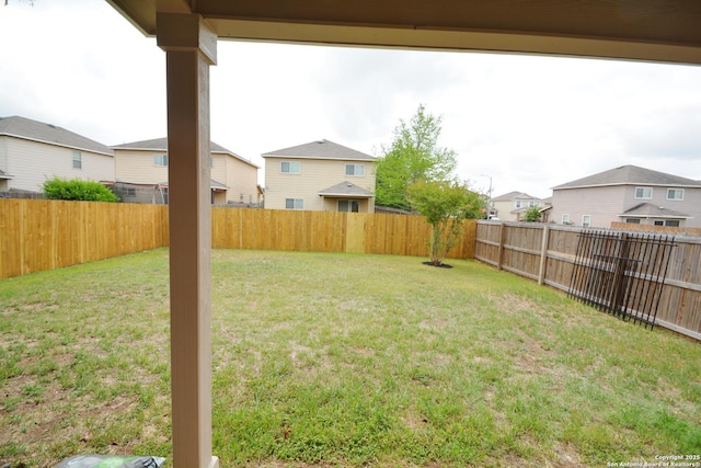 view of yard with a fenced backyard and a residential view