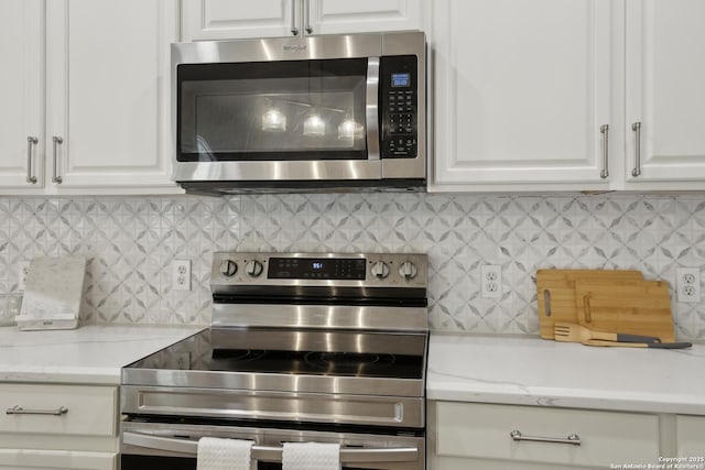 22010 Dolomite, San Antonio, TX 78259 - kitchen featuring stainless steel appliances, light stone countertops, decorative backsplash, and white cabinetry